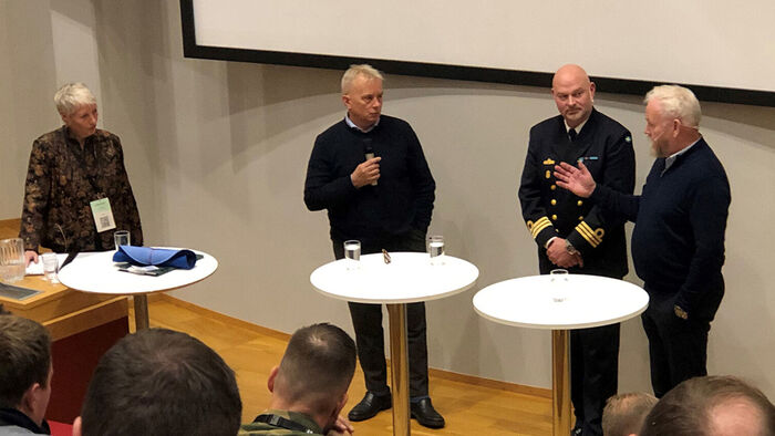 Bildet viser Knut Storberget, Per Lund og Harald Sunde i engasjert debatt ledet av Kari Toft helt til høyre i bildet.