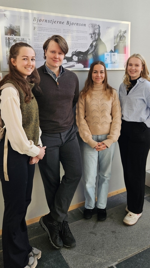 Fire studenter står foran et bilde av Bjørnstjerne Bjørnson.