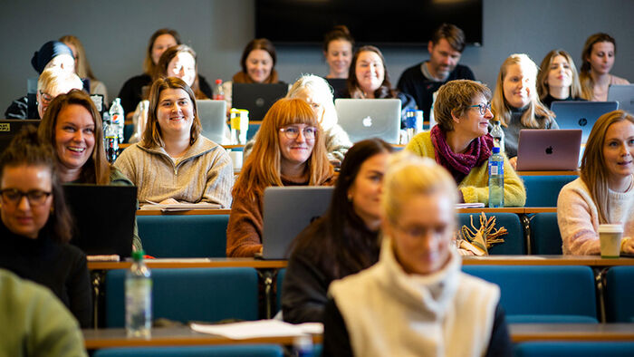 Studenter som sitter i en forelesningssal. 