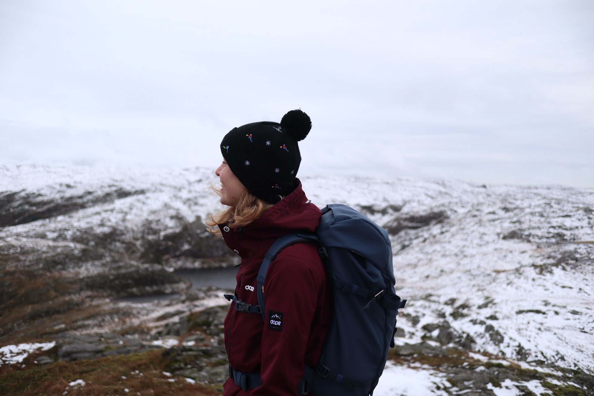 Exchange student dressed in woollen clothes on a snow covered mountain top