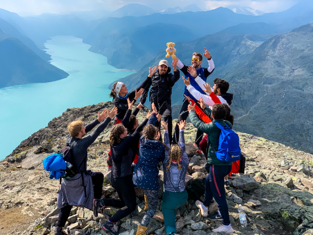 A group of students standing a top of a mountain