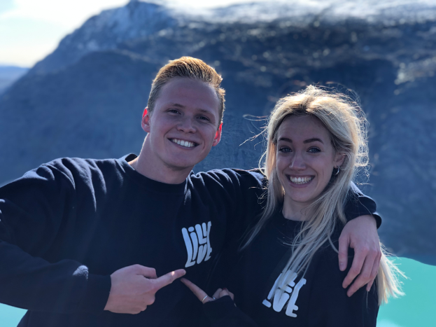 Exchange students posing with volunteer shirts on a hike