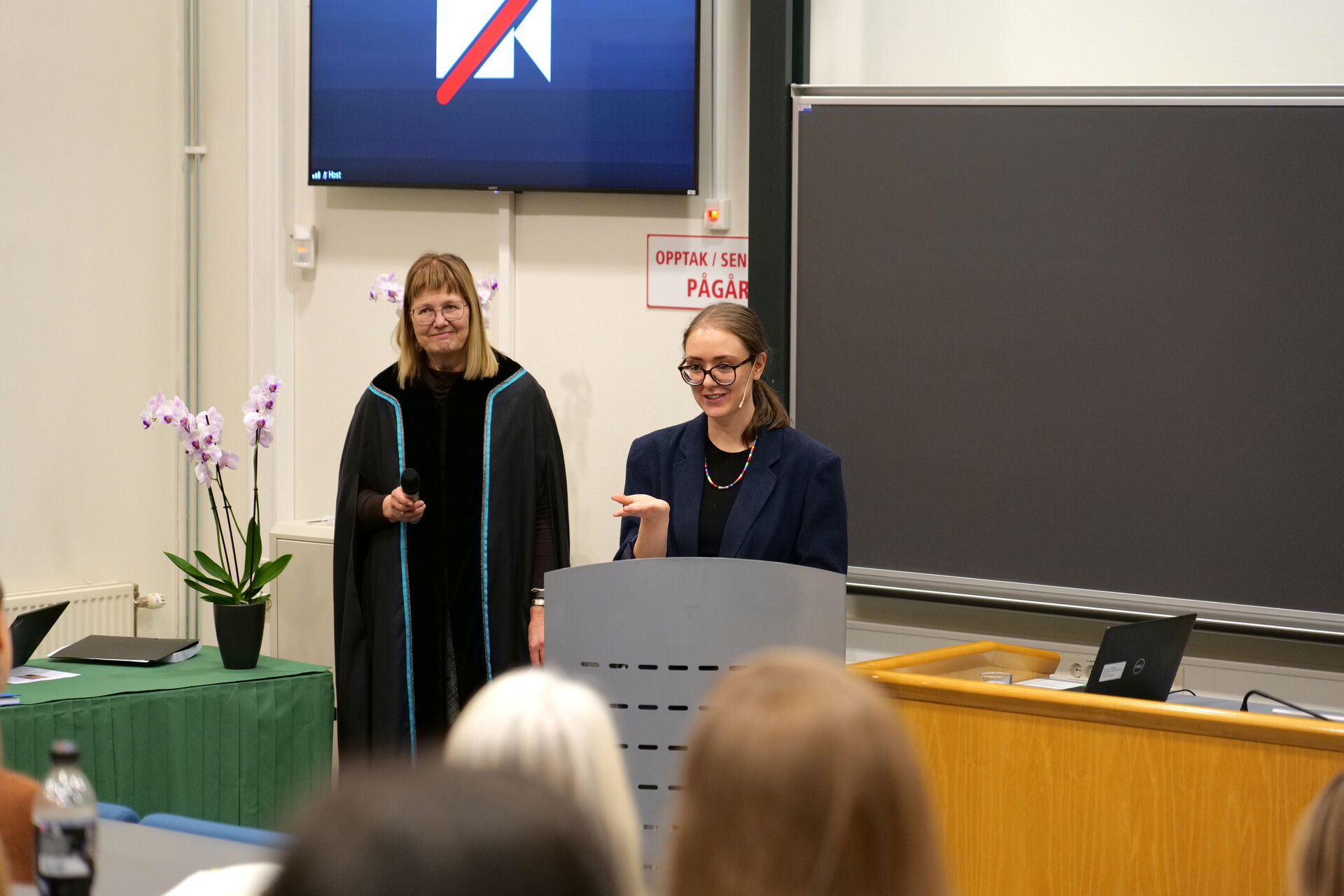 Disputasleder professor Lise I. Kulbrandstad og doktorand Beate Kristin Leirpoll foran i auditoriet.
