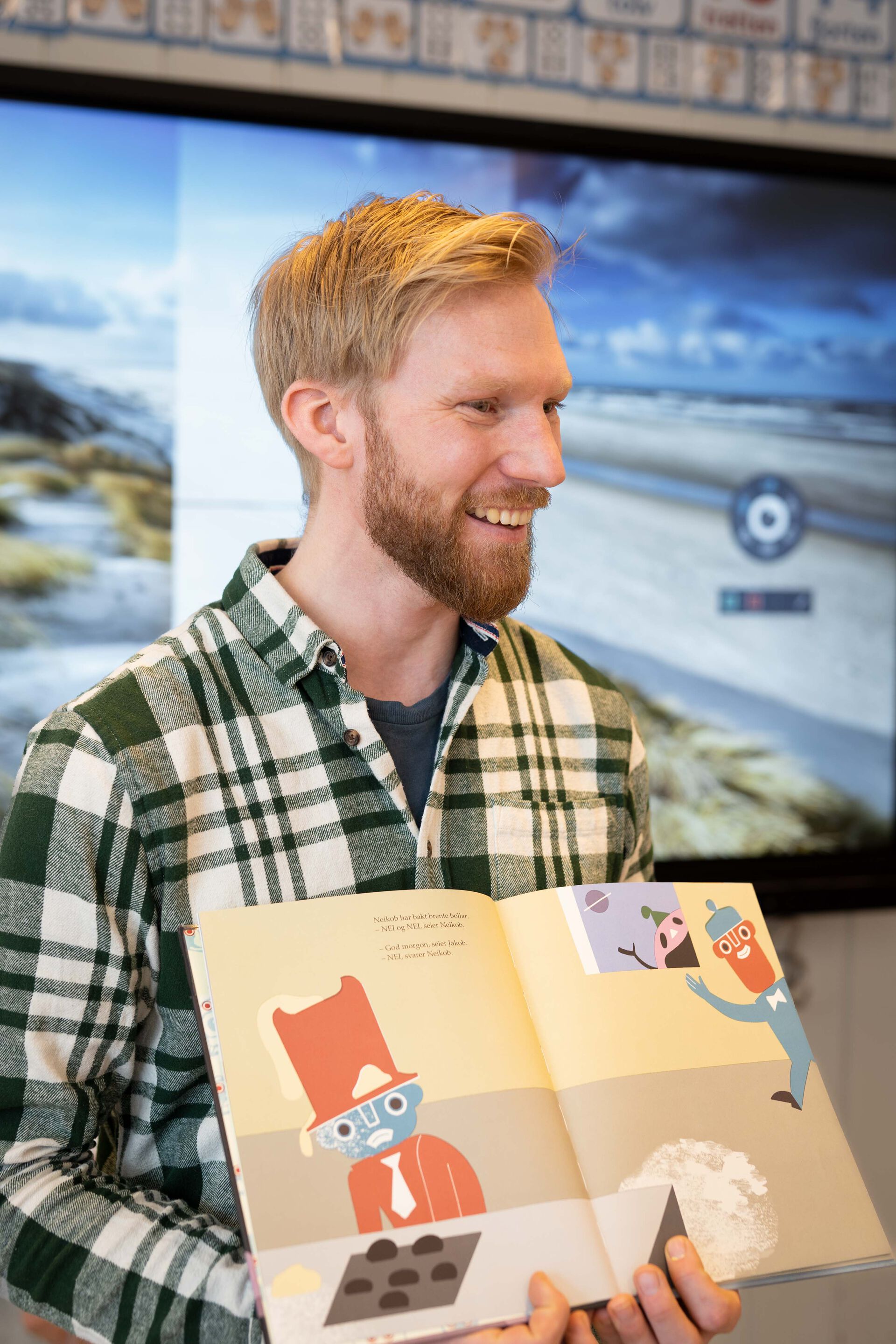 Nærbilde av Halvor som holder en bok mens han ser til høyre (ut i klasserommet).