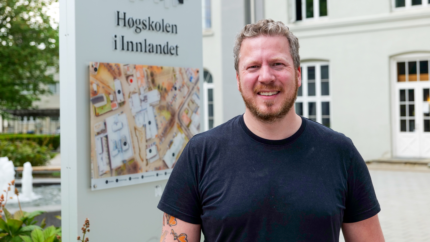 Eirik Skjelstad foran et Høgskolen i Innlandet-skilt på campus Hamar