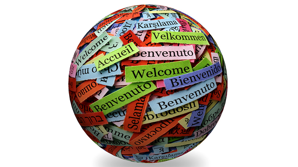 Bilde viser en jordklode som er dekket med ordet velkommen på mange ulike språk. Bildet er hentet fra colourbox.