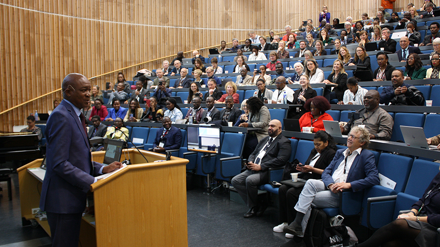 Douglas Syakalima på talerstolen foran publikum i salen