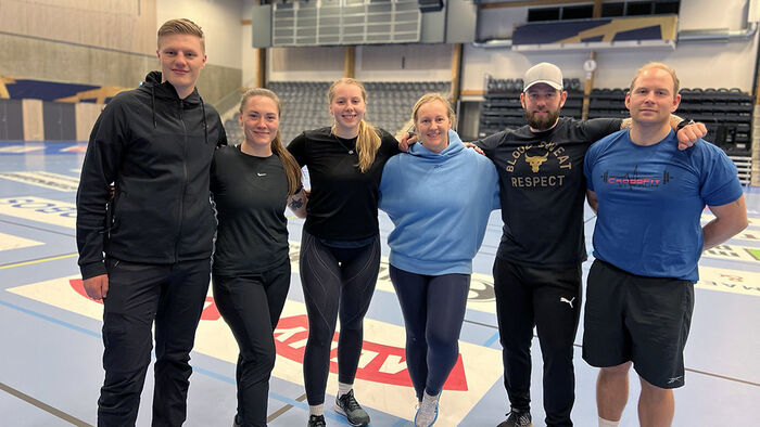 Seks smilende idrettsstudenter i Terningen Arena. 