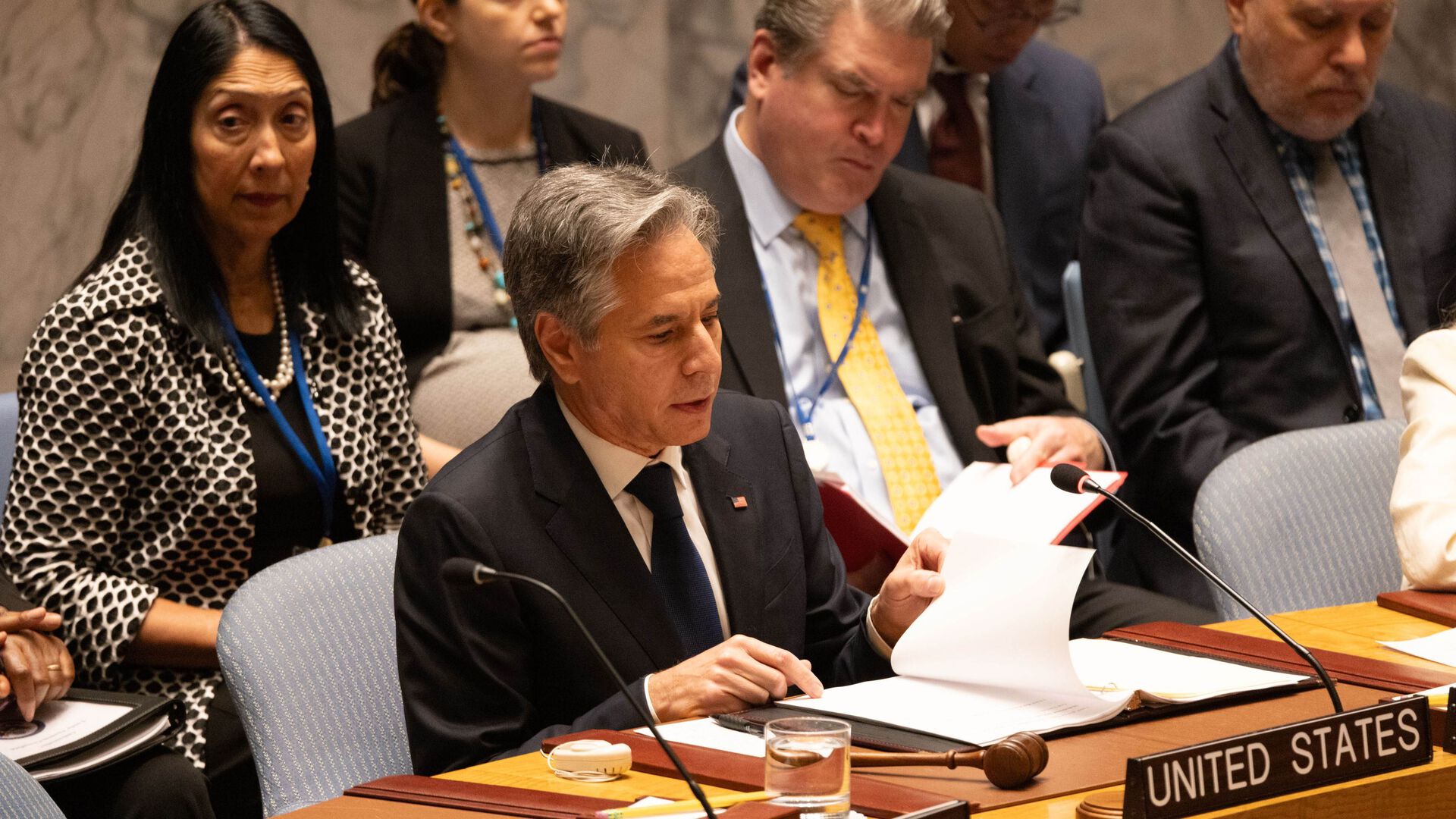 USAs utenriksminister Antony Blinken sitter omringet av andre folk snakker i FNs sikkerhetsråd. Skilt hvor det står United States står  på pulten foran ham.