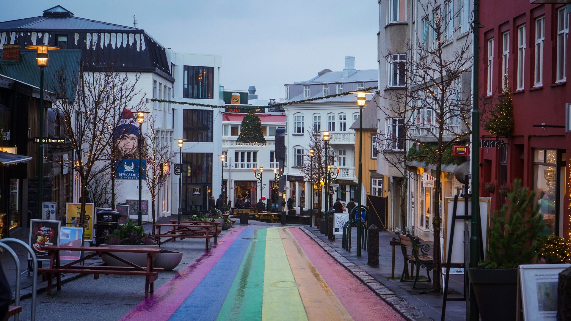 Person på gate malt i regnbuefarger i reykjavik island