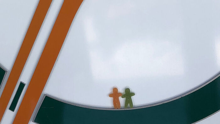 Grønn og oransje logo til Østlandsforskning med en grønn og en oransje seigmann som holder hverandre i hendene