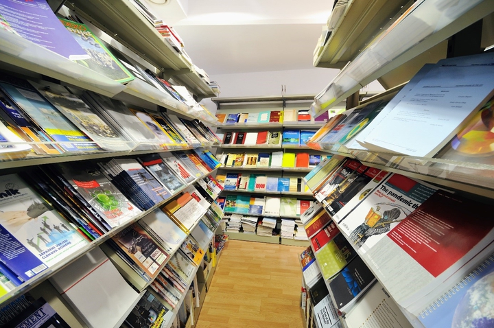 Bøker og tidsskrifter stilt opp på hyller i et bibliotek.