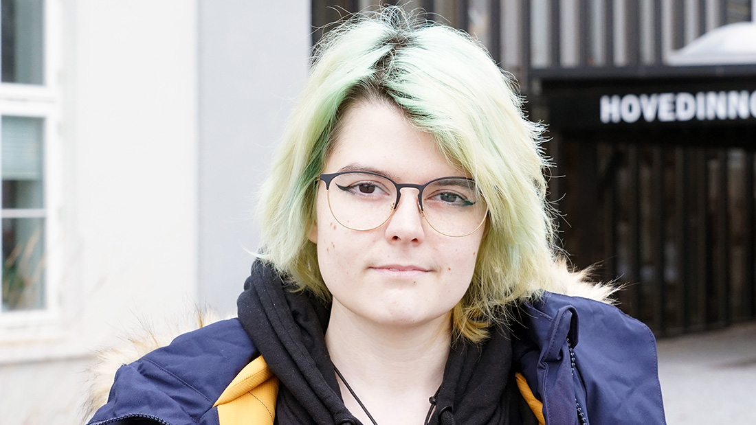 Portrettfoto av lys kvinne med briller utenfor campus Hamar. 