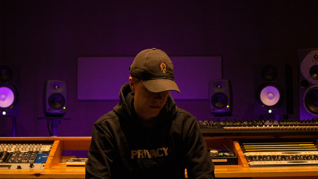 Mann med caps som sitter i et studio. 