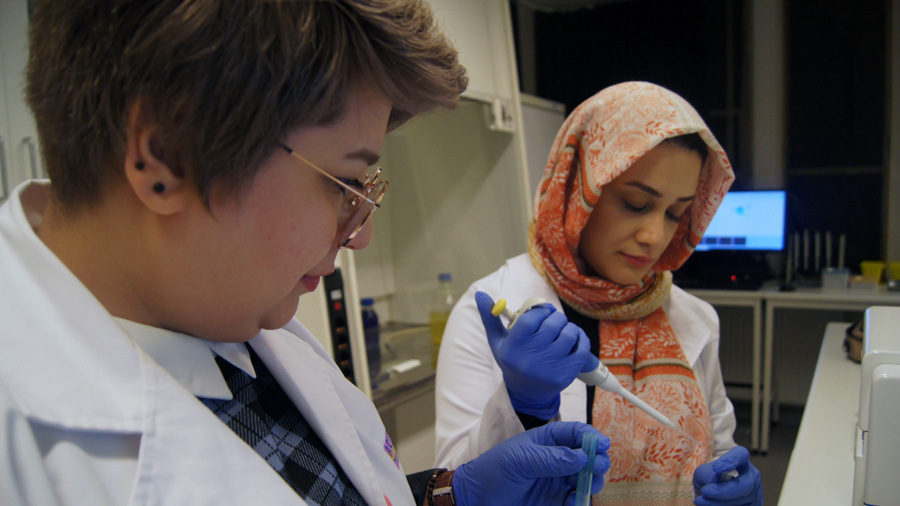 Sudi og Tahereh med et reagensrør på labben