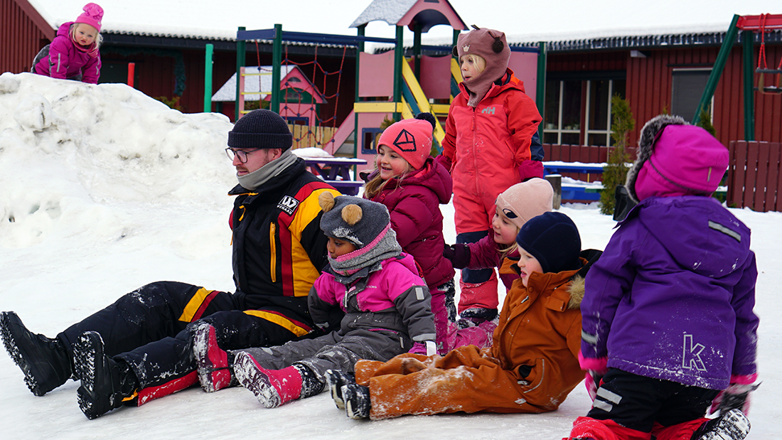 Barn som leker i snøen ute. 